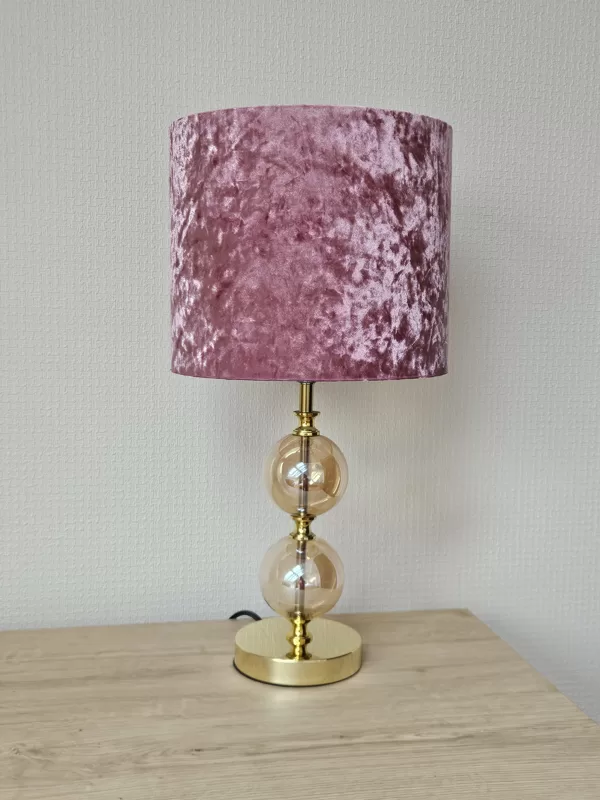 Grezna galda lampa ar velūra abažūru un zelta krāsas pamatni.